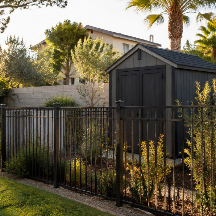 Dark metal fence around a landscaped backyard with a storage shed
