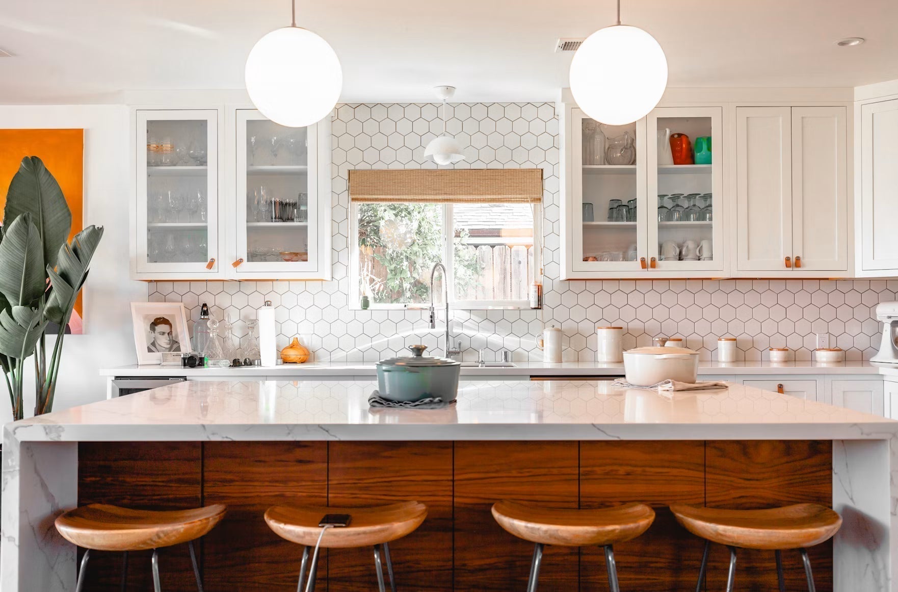 Bright white kitchen with an island and wooden stools