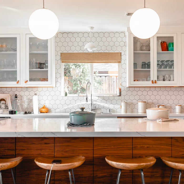 Bright white kitchen with an island and wooden stools