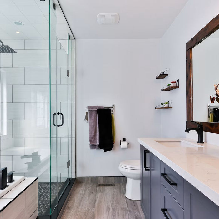 Bright remodeled bathroom with a glass shower and white vanity