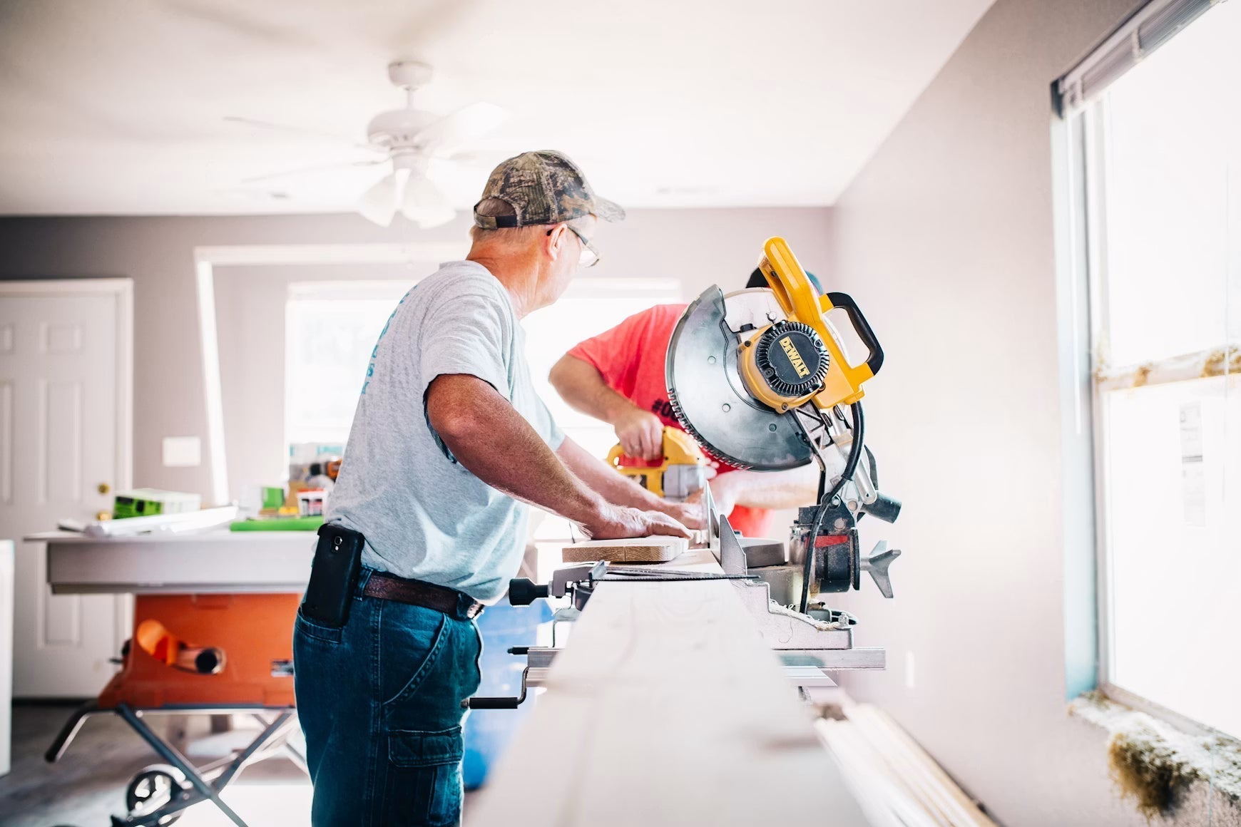 Carpenter cutting wood with a miter saw during a home repair