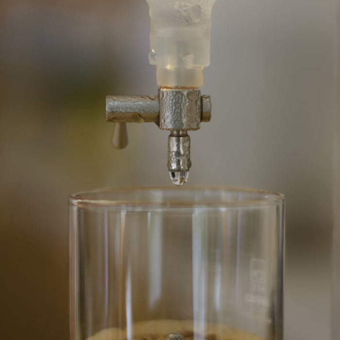Countertop gravity water filter dispensing water into a glass