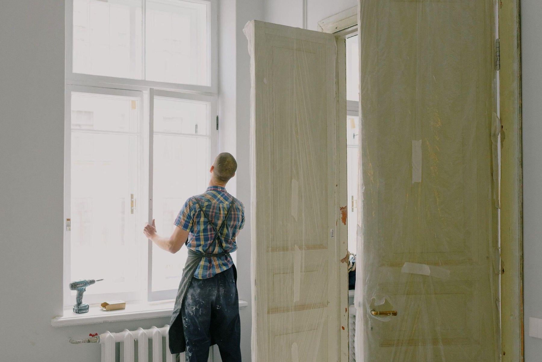 Handyman installing a window during a major home repair