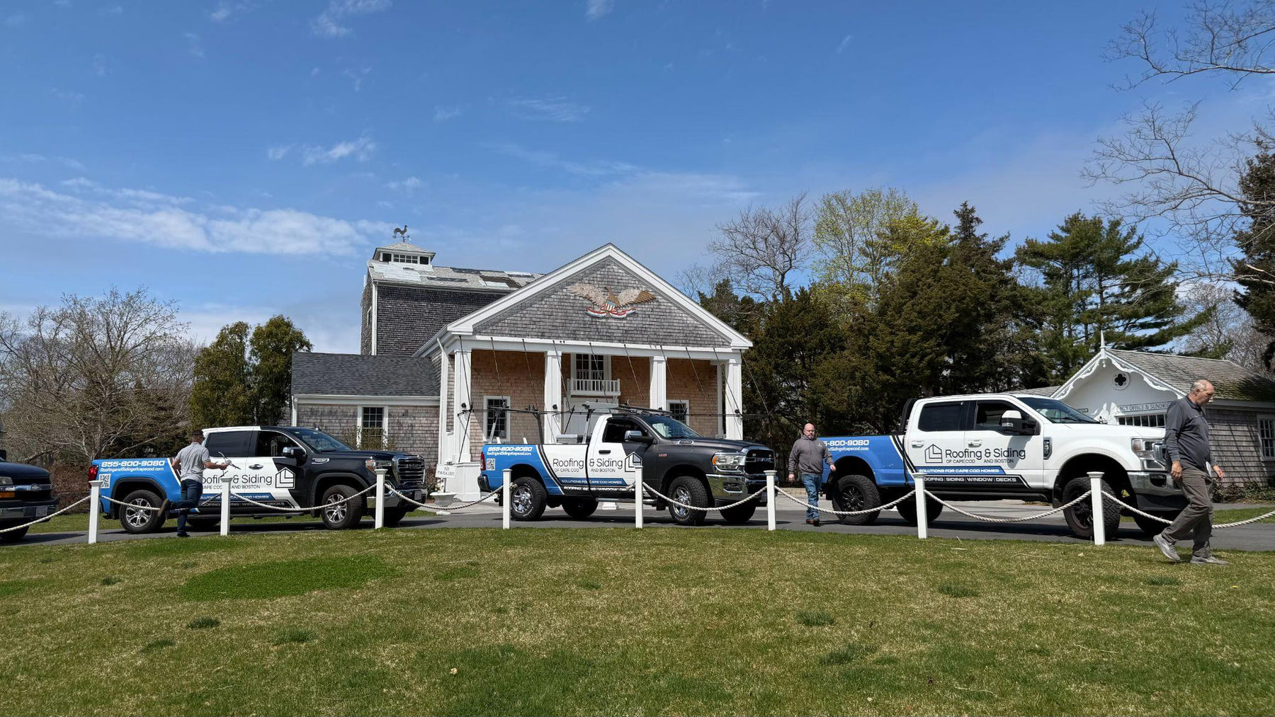 Roofing and siding contractors outside a Cape Cod property