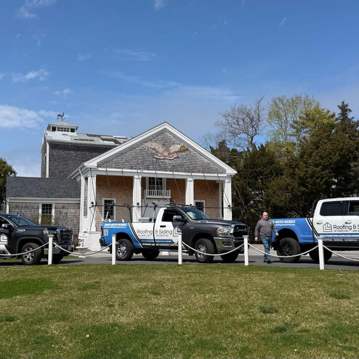 Roofing and siding contractors outside a Cape Cod property