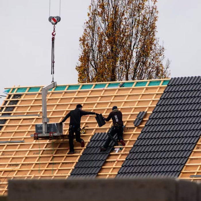 Roofers installing tiles on a residential roof