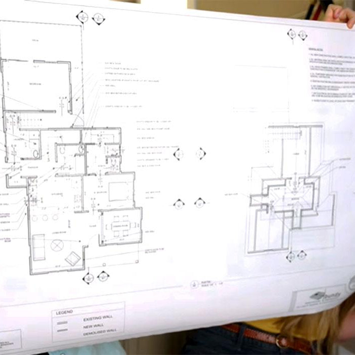 Homeowners reviewing architectural plans for a remodeling project