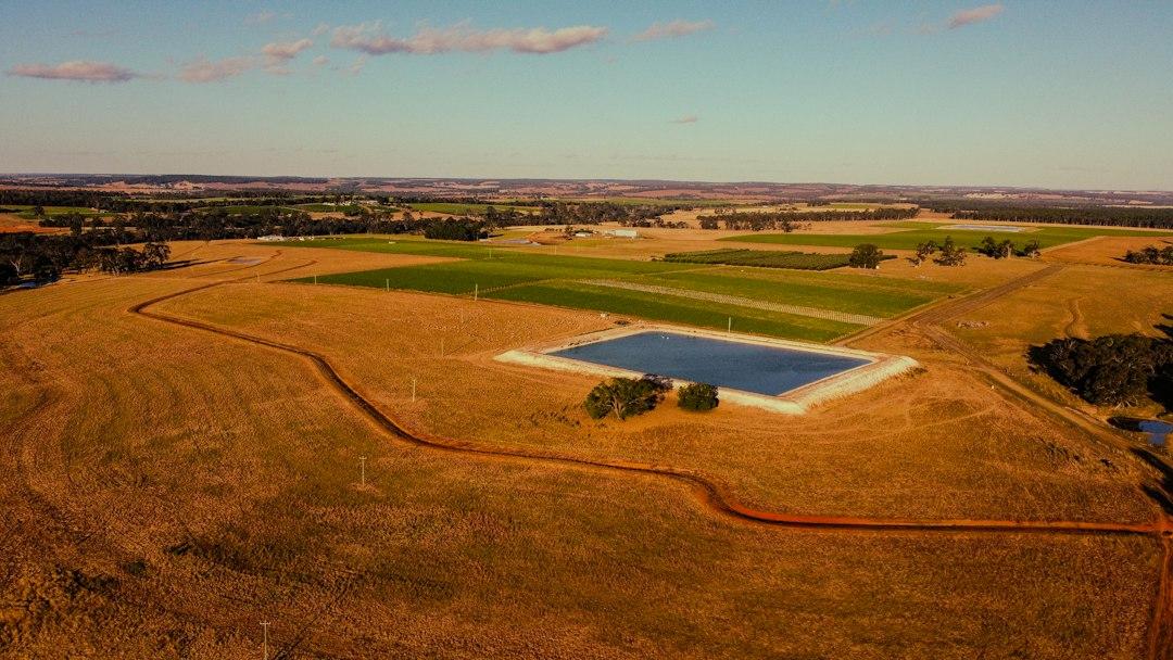 Aerial view of rural acreage with fields and a farm dam