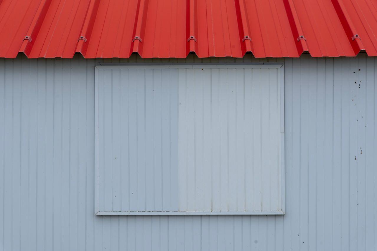 Corrugated red metal roof on a simple shed wall