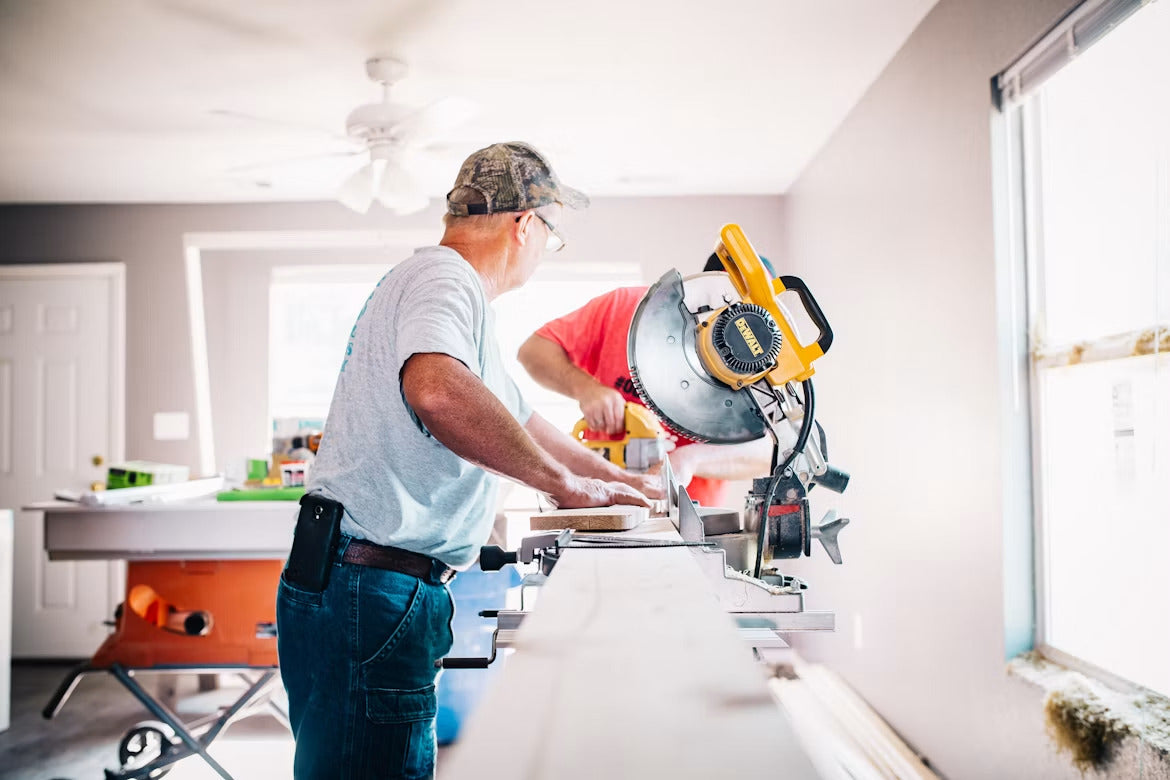 Worker operating a miter saw during an interior renovation