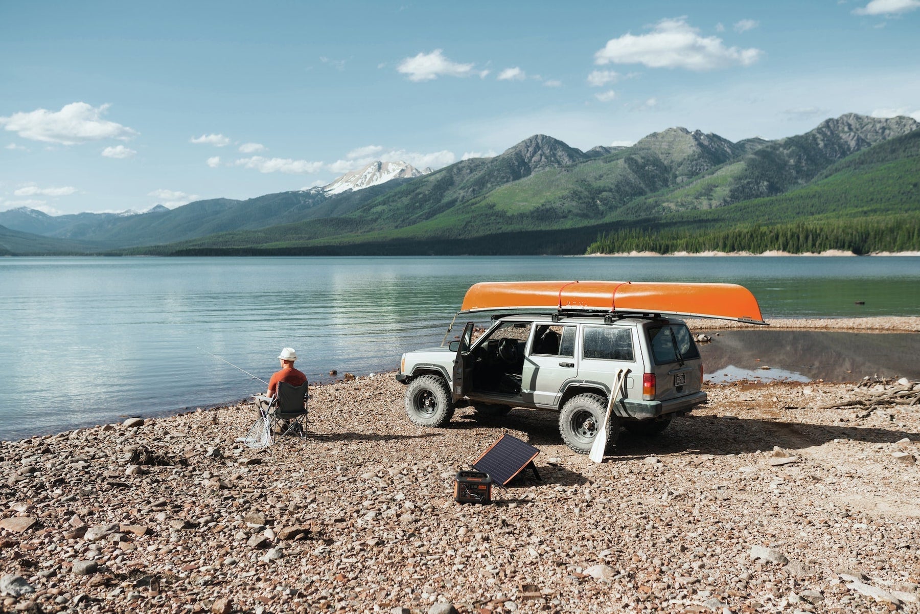 Portable power station and solar panel beside a lakeside campsite