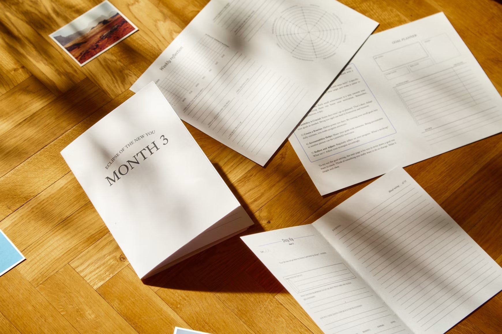 Printed manual pages arranged across a wooden table