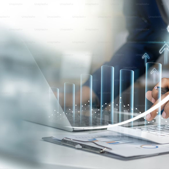 Hand using a laptop beside an upward financial chart graphic