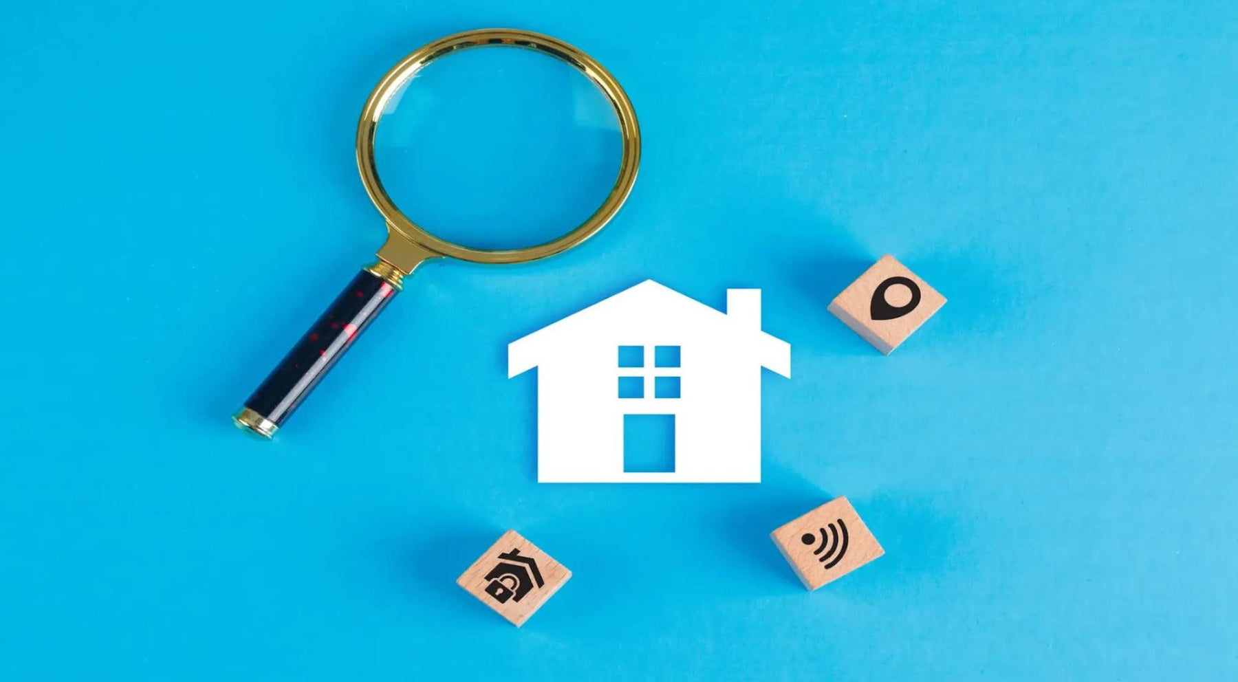 Magnifying glass beside a model house and rental property icons