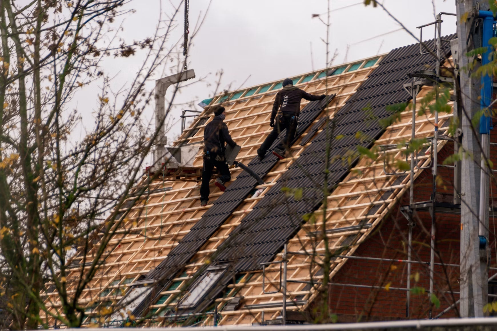 Roofers replacing shingles on a residential roof