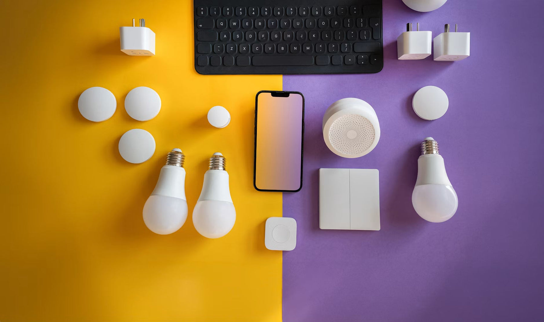 Smart home devices arranged beside a phone and keyboard