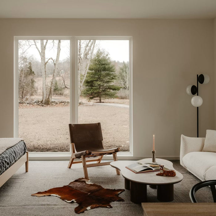 Traditional home living space with neutral furnishings and a large window