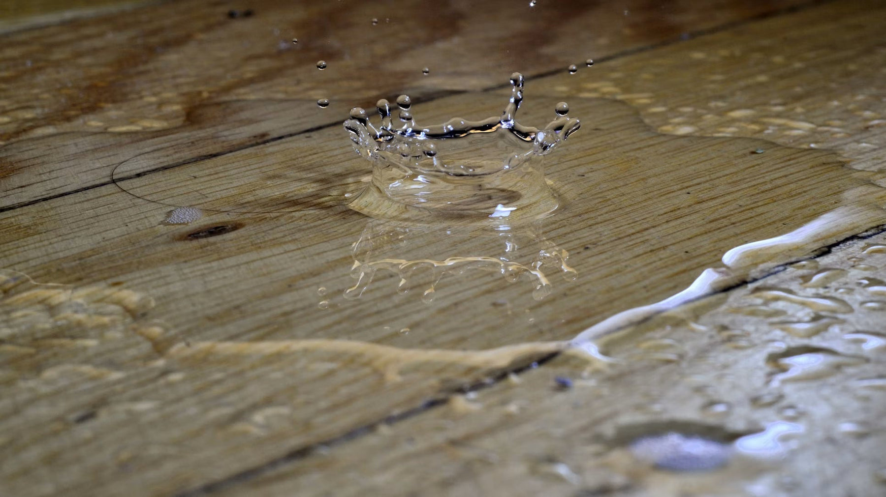 Water spreading across a damaged wood floor