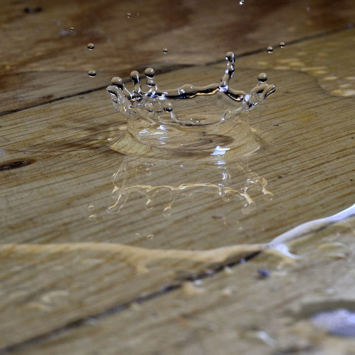 Water spreading across a damaged wood floor