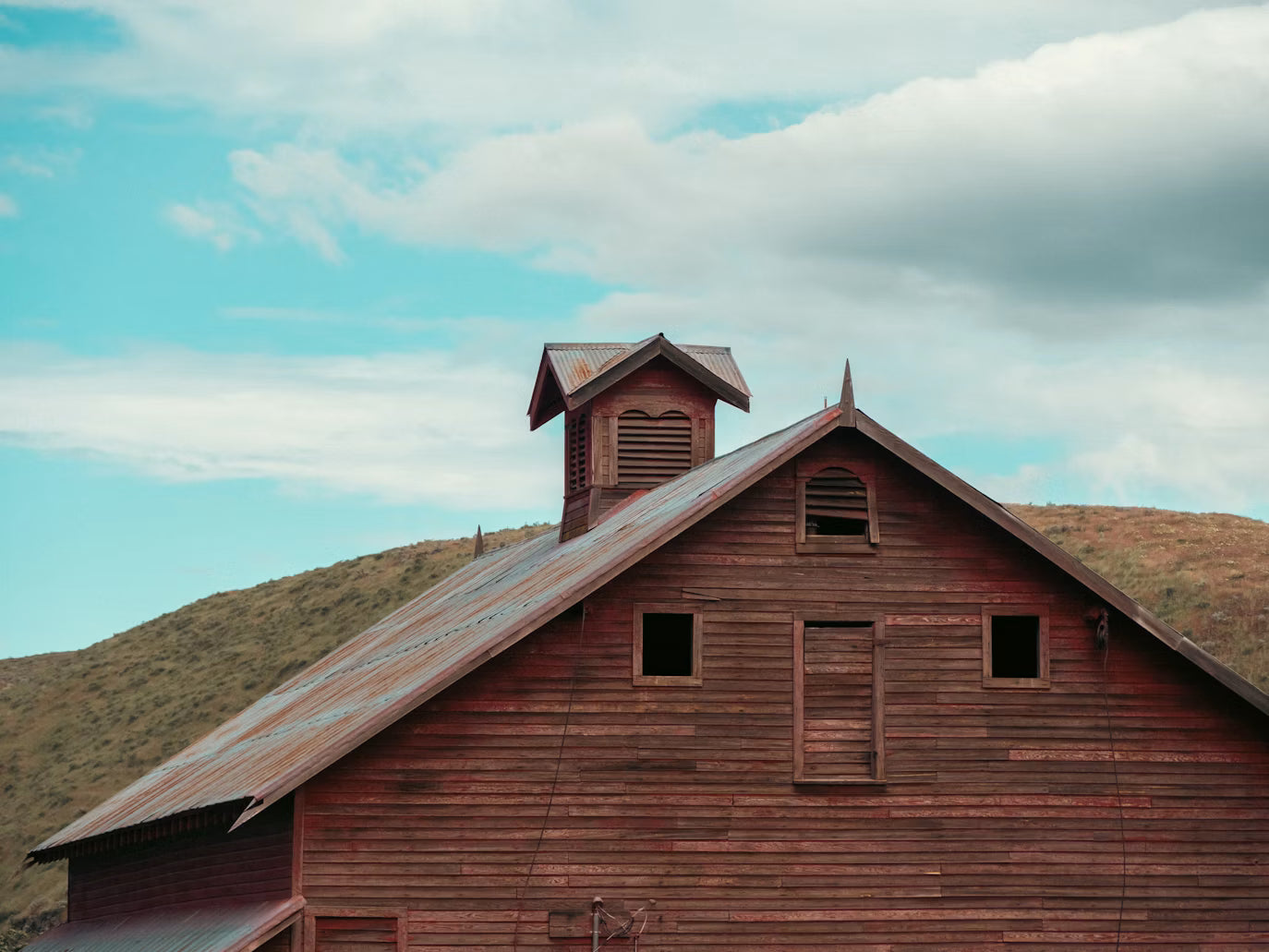 Weathered wooden barn with a sloped metal roof