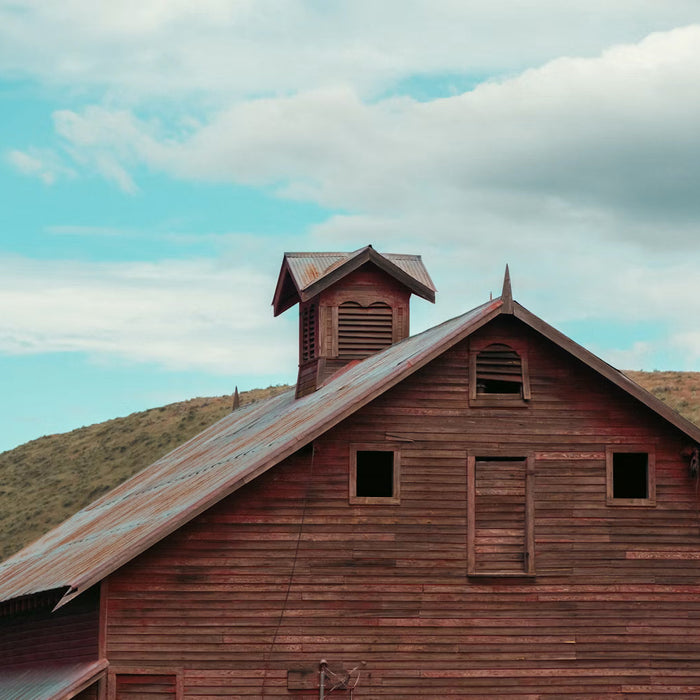 Weathered wooden barn with a sloped metal roof