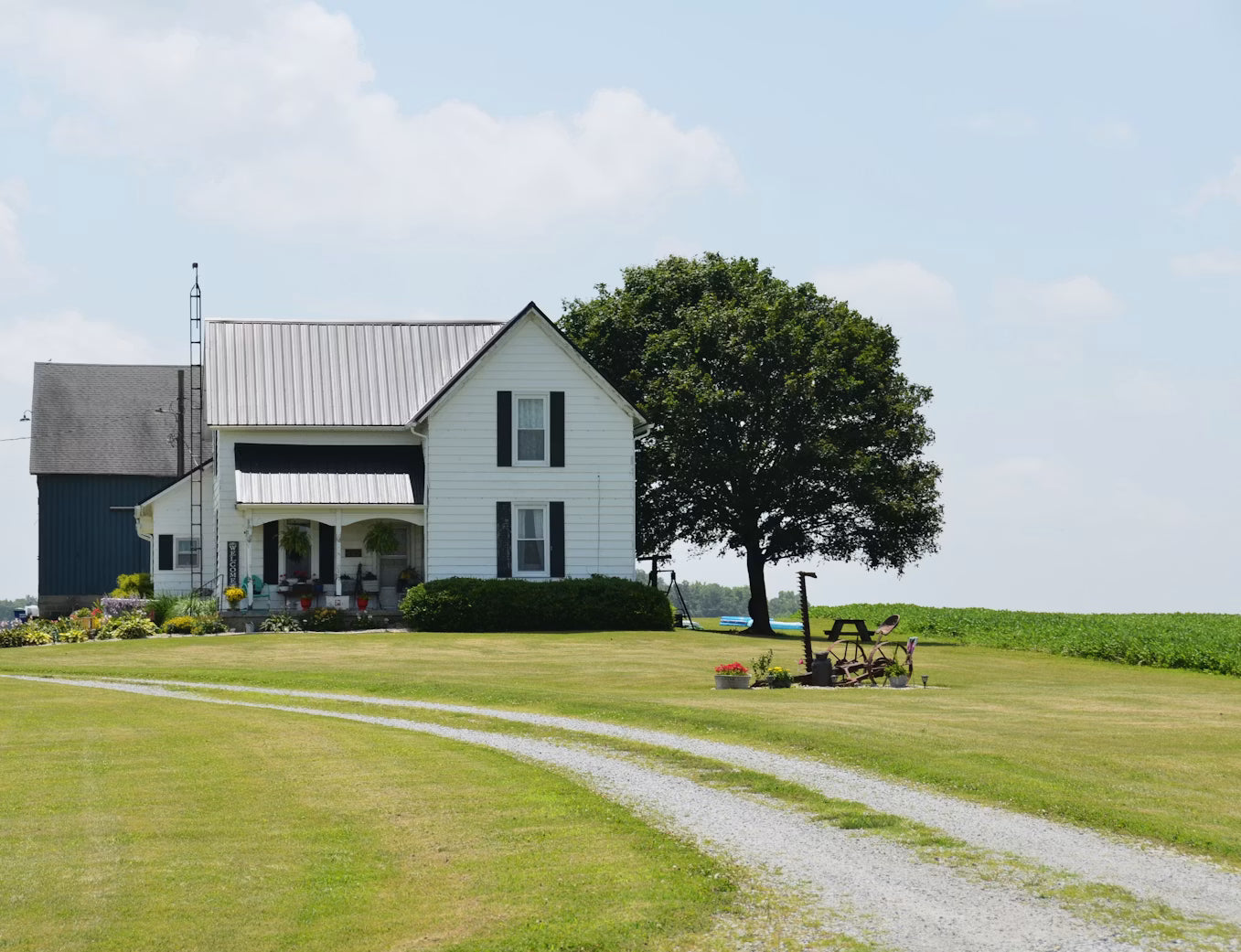 White farmhouse beside a gravel country road