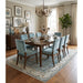 Aqua and ivory Oushak rug under a dining table and chairs