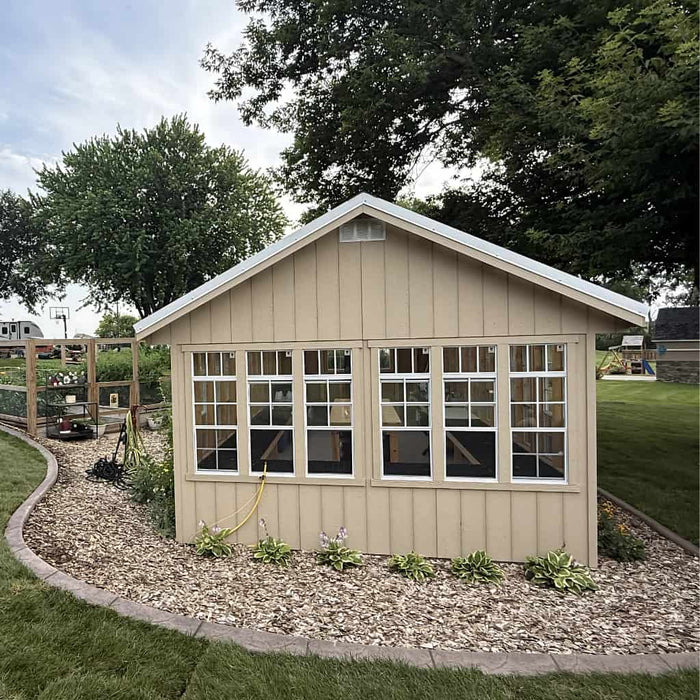 Beige ez fit greenhouse with large windows in a backyard setting