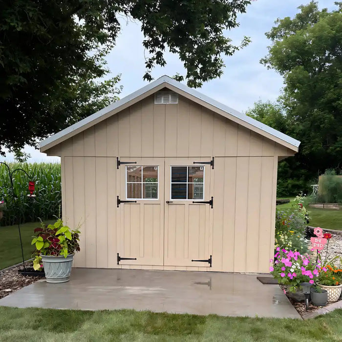 Beige 12x24 ez fit greenhouse with a small garden in front on a clear day