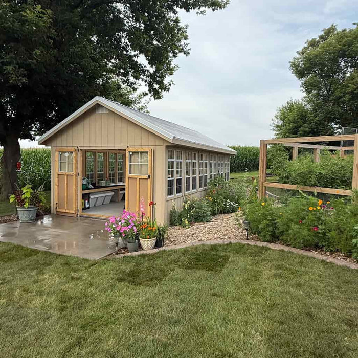 12x24 ez fit greenhouse kit in a garden with flowers and plants around