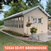 Beige greenhouse with plants in a garden setting, labeled '12x24 EZ-FIT GREENHOUSE'.