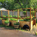 Outdoor Living Today 8x12 Deer Proof raised garden bed with plants and a tree in the background