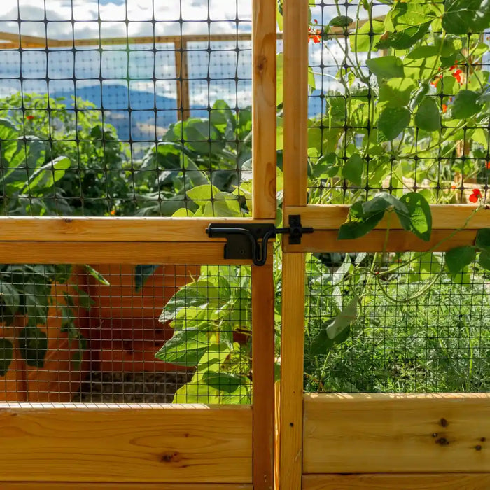Outdoor Living Today 8x16 Deer Proof cedar raised garden bed gate with metal mesh in a lush green garden setting