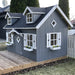 Palmako marie 9x6 playhouse kit with gray exterior and white trim on a grassy area