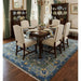 Oushak rug staged beneath a dining table and chairs in a dining room