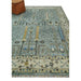 Angled room view of the aqua and ivory rug styled with an ottoman