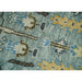 Close view of hand-knotted wool texture and tree motif details in aqua and ivory