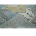 Folded corner showing face and reverse of beige, blue and ivory hand knotted wool rug