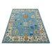 Angled view of the complete blue and ivory Oushak rug