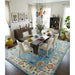 Blue and ivory Oushak rug displayed in a dining room