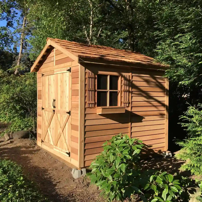 Angled exterior view of the Cedarshed Rancher cedar storage shed with windows and garden plants