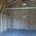 Unfinished interior of little cottage co gambrel large barn with wooden framing and drywall.