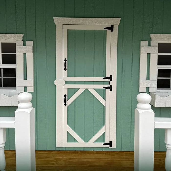Little Cottage Co Craftsman Playhouse Kit white wooden dutch door with black hardware on a green paneled wall