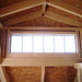 Little Cottage Co Craftsman Playhouse  Wooden ceiling with a window and exposed wooden beams