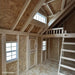 Little Cottage Co Craftsman Playhouse interior with a loft bed and windows.