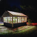 EZ-Fit Greenhouse Kit with glass panels at night, illuminated by lights inside