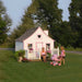 The Little Cottage Company - Gingerbread Cottage Playhouse Kit - with Mother and Child in a Backyard