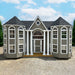 Little cottage co the grand portico playhouse kit with a gray exterior and white columns on a clear day.