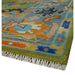 Close-up of the Oushak rug's patterned border, bound edge, and fringe.