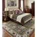 Green and ivory traditional Oushak rug staged in a bedroom